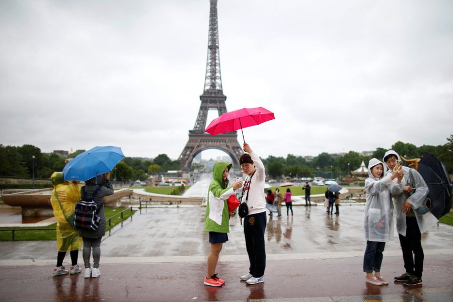 Tourists stroll on the Trocadero square, in front of the Eiffel Tower during a rainy day in Paris, France, May 30, 2016.   REUTERS/Charles Platiau